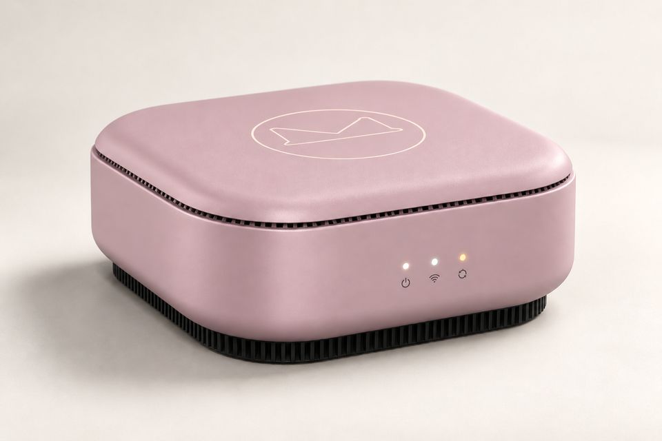 The Box Plus concept in Blush Pink: a low square box in a dusty pink with rounded corners and a gently domed lid showing the outlined Synkurl mark. Small vent slots ring the lid seam; three lights glow on the front above a ribbed black base.